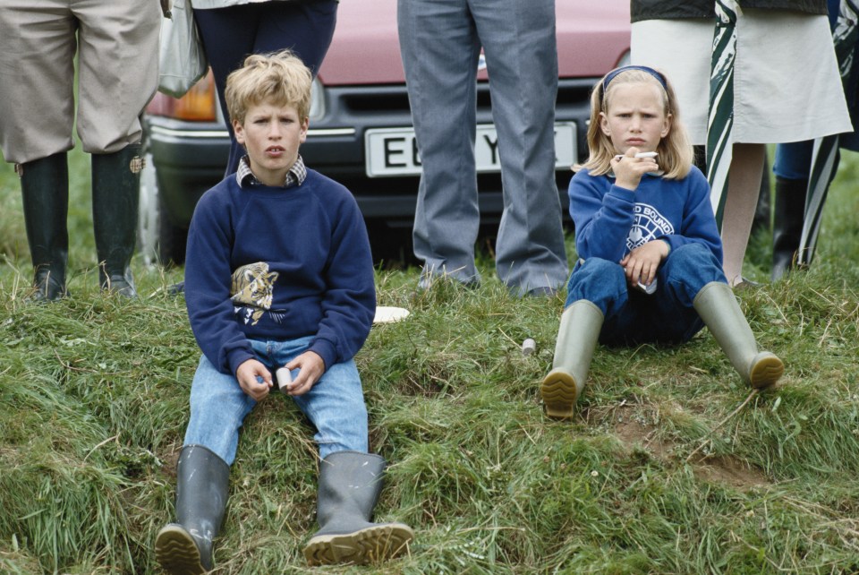 Zara and brother Peter sitting on a grassy bank in Wiltshire in July 1988