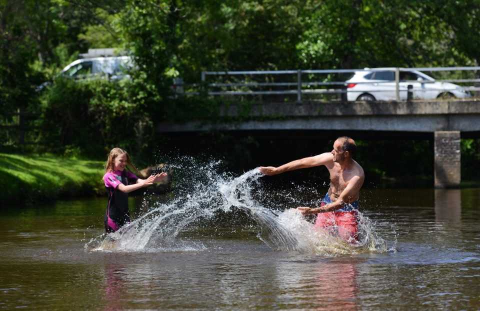  Shawn Wickett and his daughter Emily, 12, cool off with a water fight this morning in Lymington River in Hants.