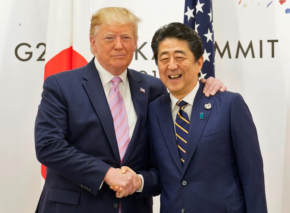 President Trump shakes hands with Shinzo Abe – just days after blasting Japan over what he described as an unbalanced security pact