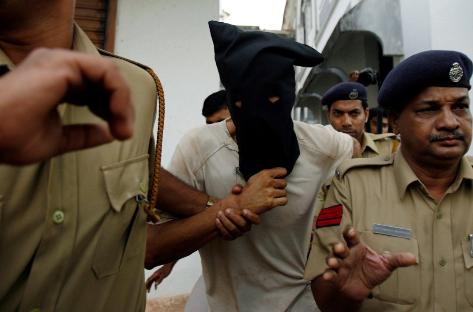 Police officers escort Samson D’Souza (C) after his court appearance in Mapusa March 10, 2008