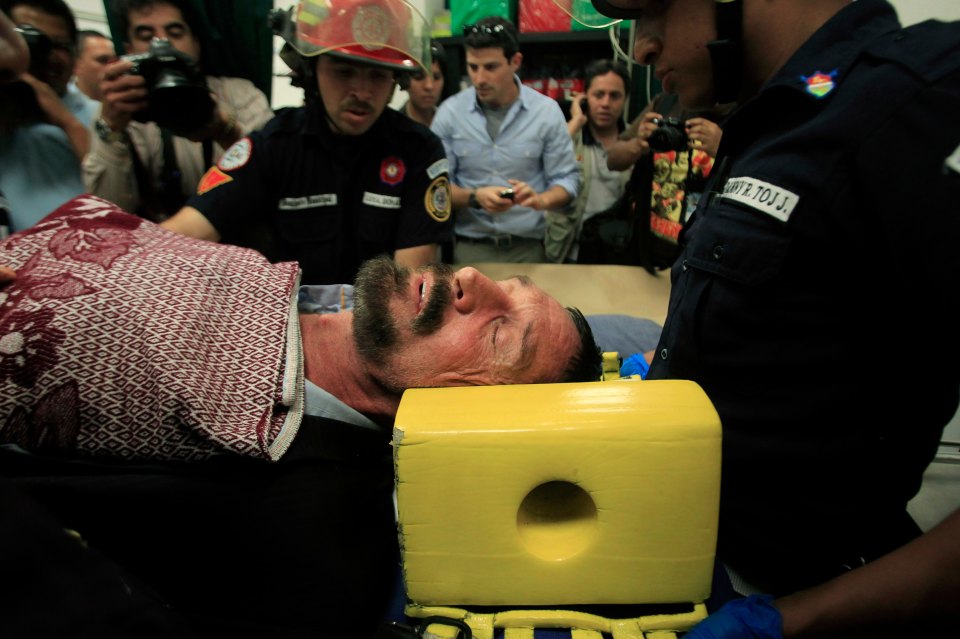  McAfee is seen lying in a stretcher after allegedly experiencing heart issues following his arrest in Guatemala