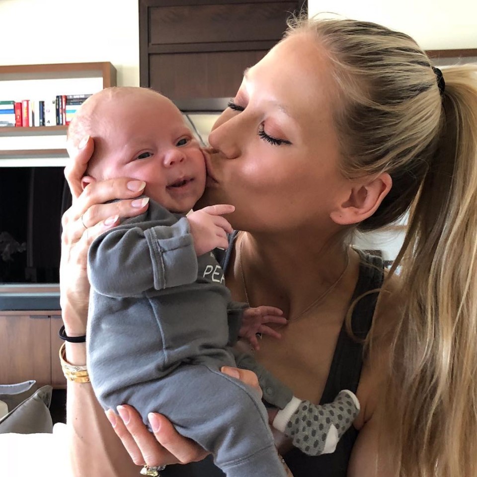 The former tennis ace plants a kiss on a newborn Nicholas