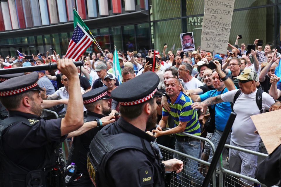  Supporters of Tommy Robinson face off with officers armed with batons outside the Old Bailey in London after the verdict was given