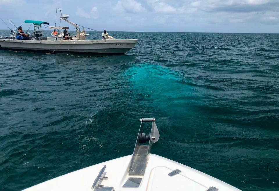  A recovery team from the  Bahamas Police Marine Unit and Support Team stands by at the wreckage site