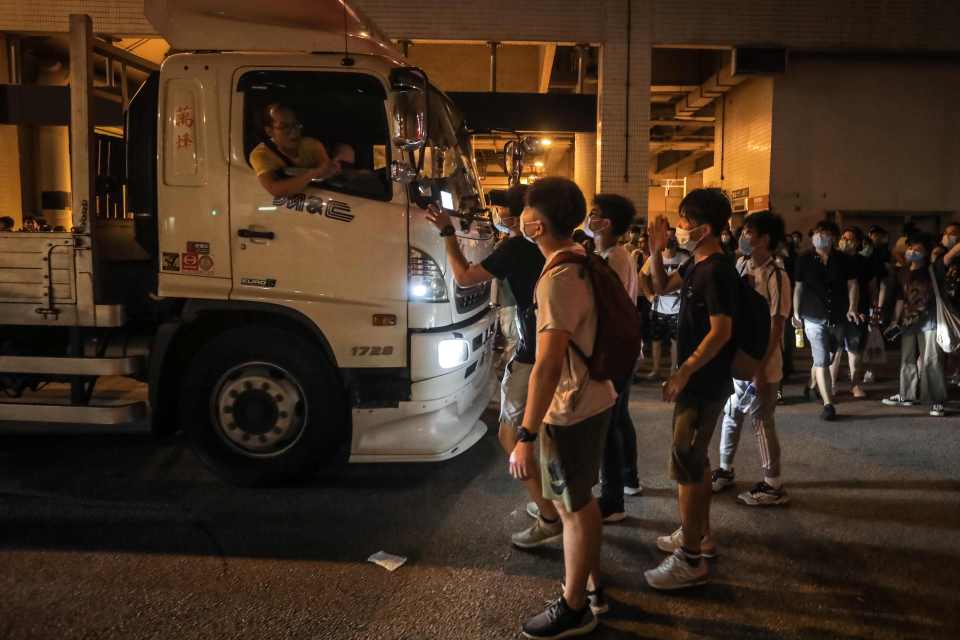  Protestors in Hong Kong argue with a truck driver as they block a road