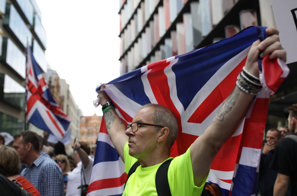  A Robinson fan holds up a Union Jack flag during protests