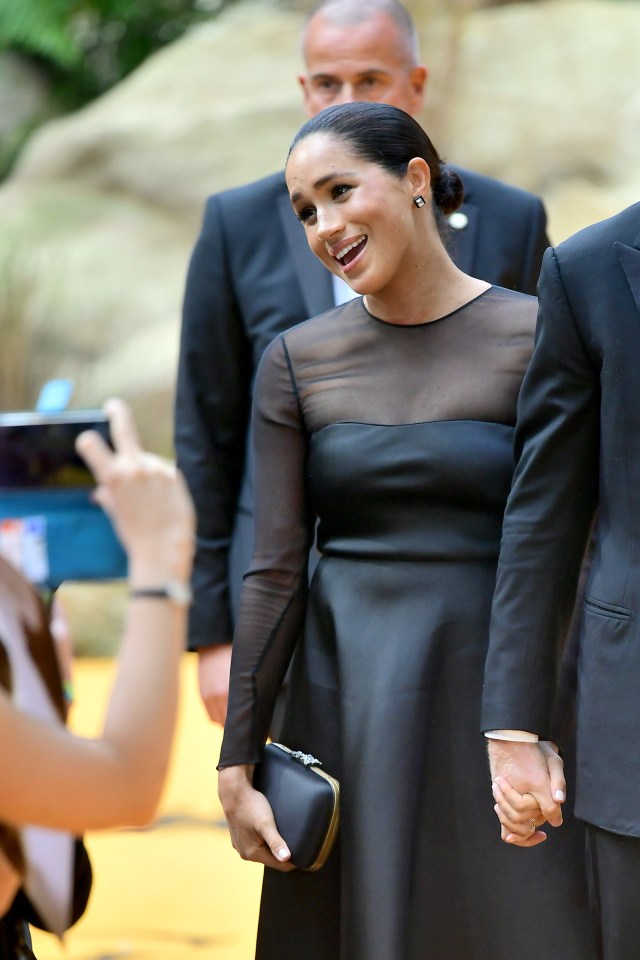  Meghan chats with fans while holding a Gucci black clutch