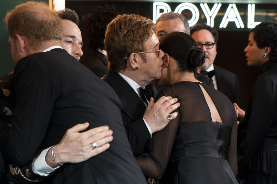  Elton John whispers in Meghan's ear at the Lion King premiere