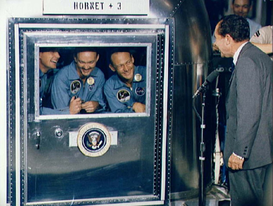  US President Richard Nixon welcomes the Apollo 11 astronauts aboard the USS Hornet in the Pacific Ocean, July 1969. Confined to the mobile quarantine facility are, from left: Neil Armstrong, Michael Collins and Edwin Aldrin