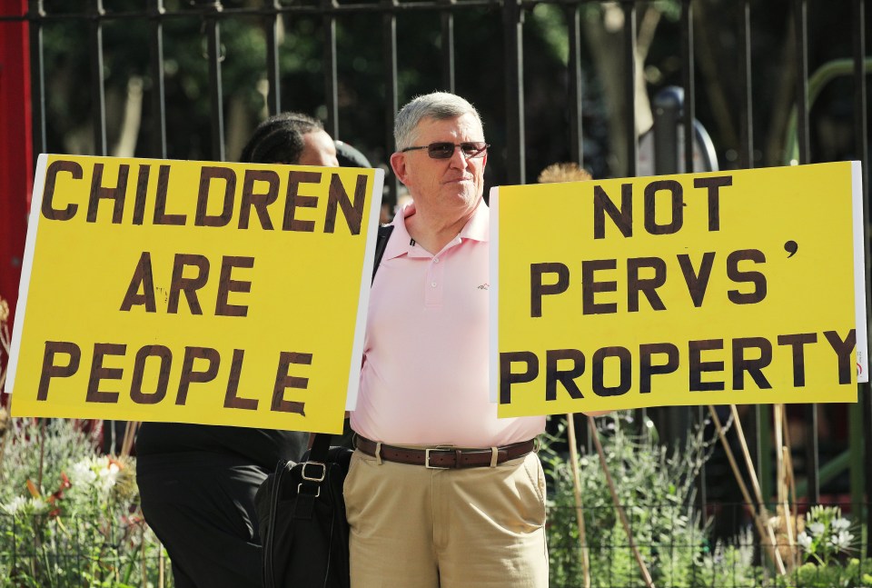 A protester holds up signs outside the courthouse ahead of Epstein’s bail hearing