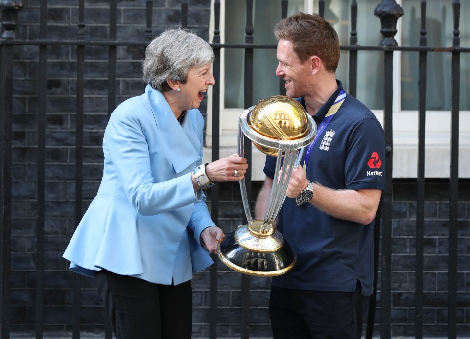  The PM laughs as she's handed the trophy by England cricket captain Eoin Morgan