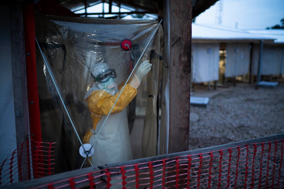  A health care worker enters an isolation pod to treat an Ebola patient