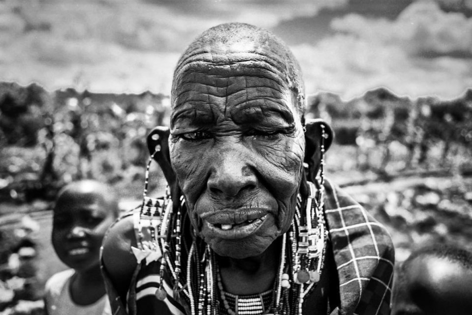 A stunning Maasai face. This woman measured her age against the tree growing in their settlement