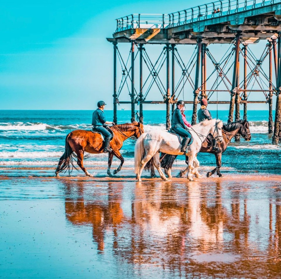 Here we see beach riders in Salt Burnby, Yorkshire, where the sea and sky are beautifully reflected against the wet sand