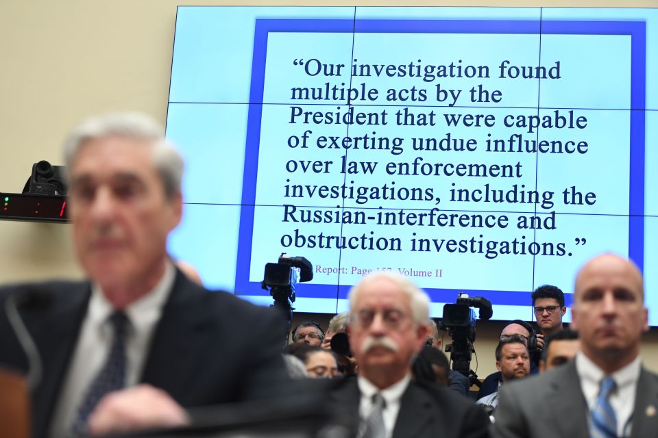  A screen at the hearing displays a quote from the Mueller report claiming Trump tried sort to influence investigations