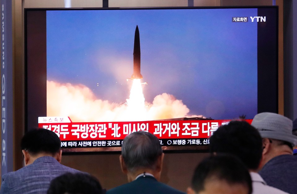  People watch a TV showing North Korea's missile launch during a news programme