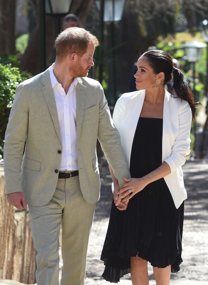  Meghan doubles the intimacy by placing a second hand on top of Harry's