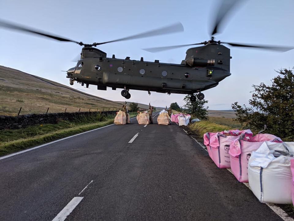  The Chinook leaves sandbags on the side of the road