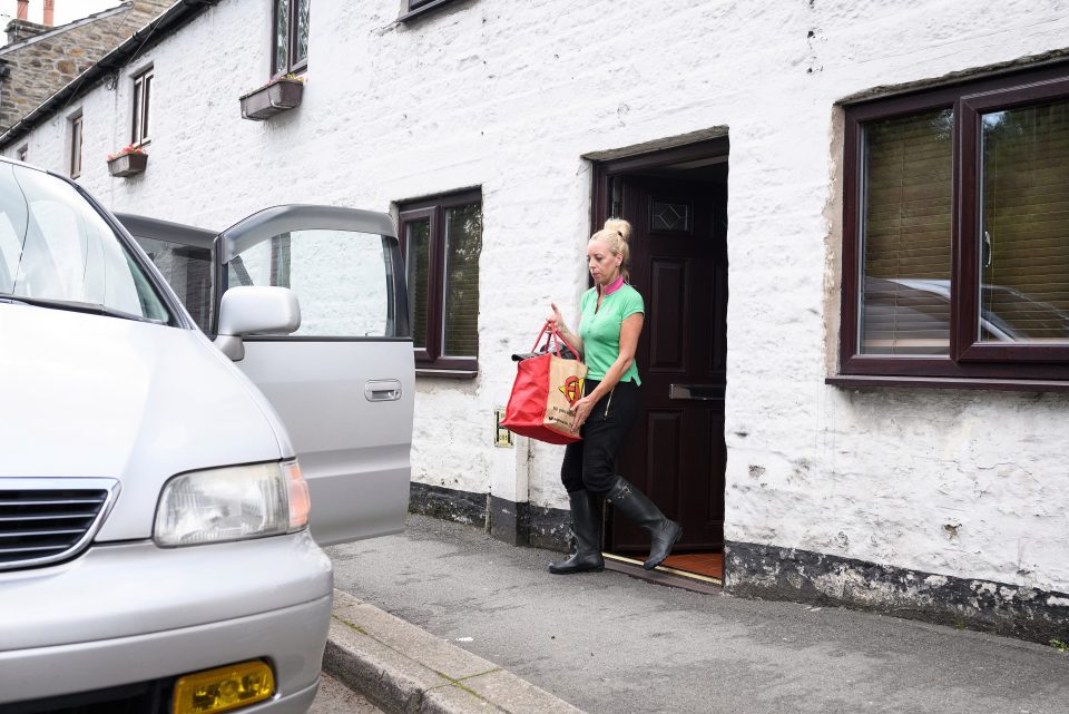  A resident rushes to remove items from a house after locals were told they could return to their homes below Toddbrook Reservoir