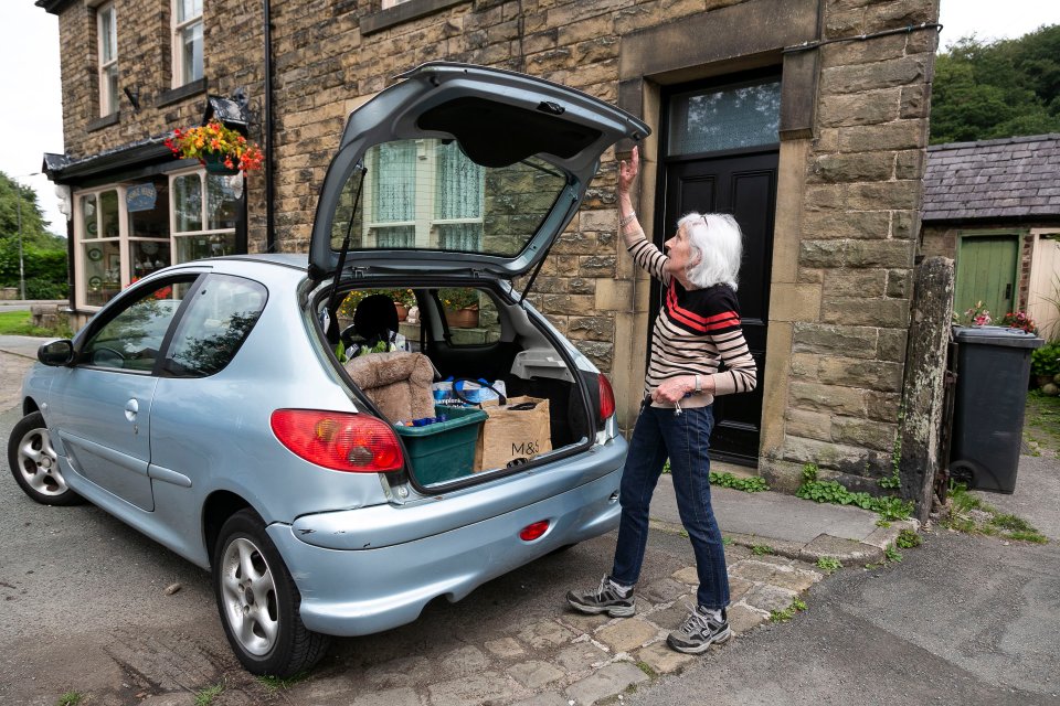  Val Fallon moves items from her home in Whaley Bridge, Derbyshire