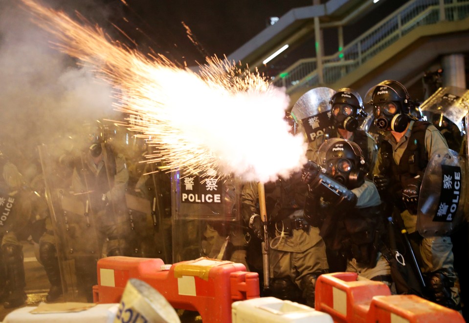  Police officers fire tear gas towards protesters during an anti-extradition bill protest in Causeway Bay, Hong Kong