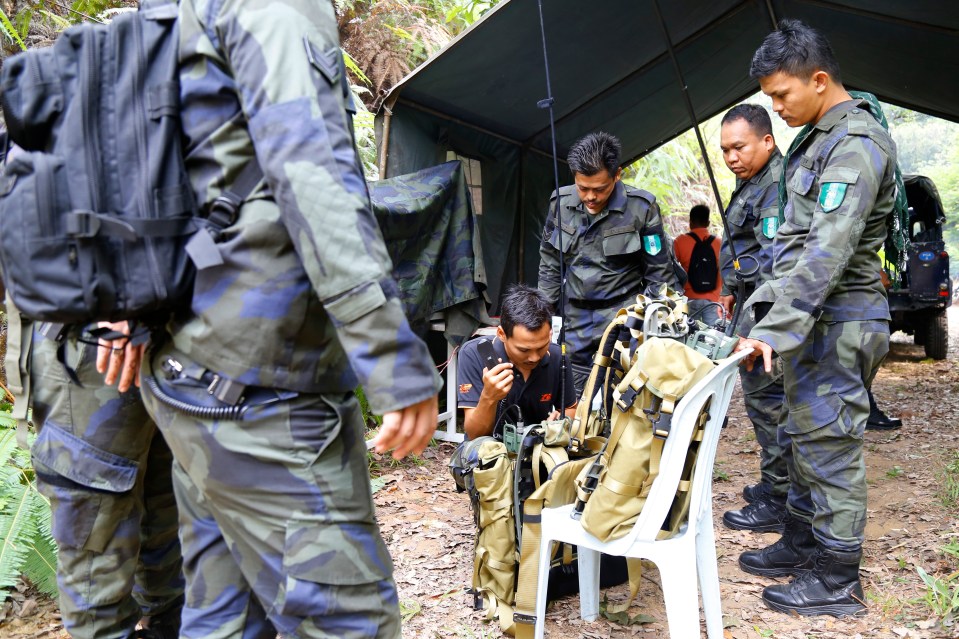  Members of General Operations Force work at a temporary operation shelter near The Dusun resort where the family were staying