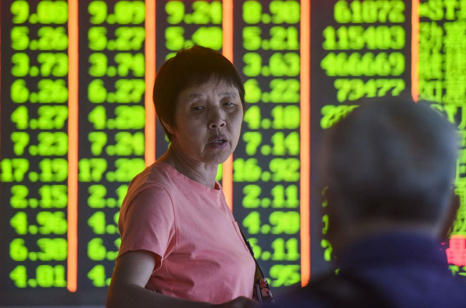  An investor in front of a screen showing stock prices at a securities company in Hangzhou, China, August 6