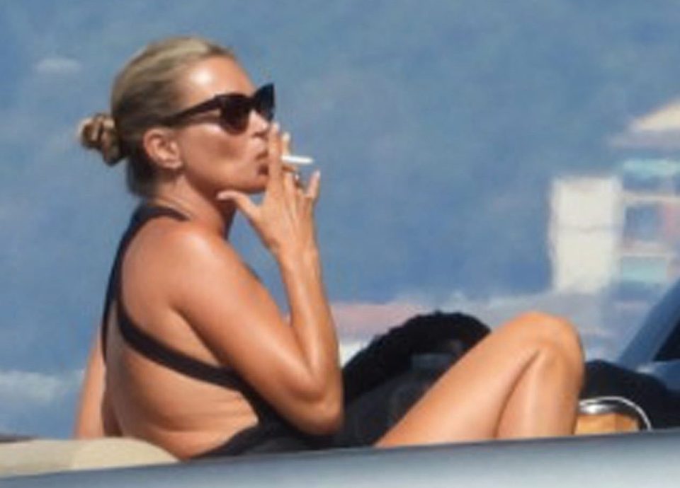  The supermodel puffed away on a cigarette as she topped up her tan