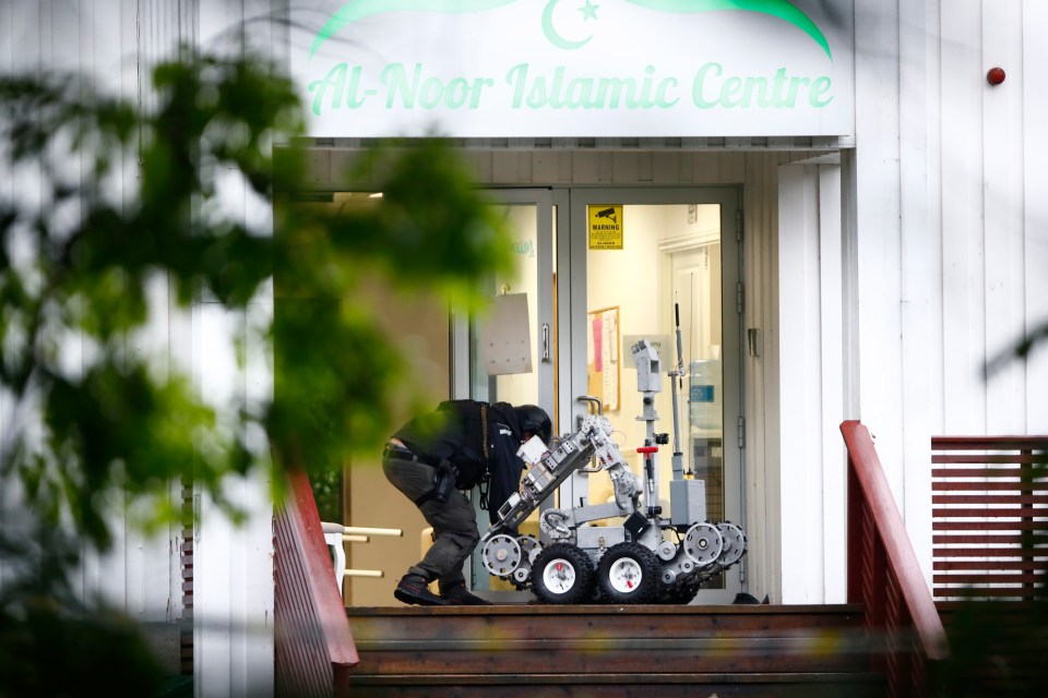  A Police officer with a robot on a site of a shooting inside the al-Noor Islamic Center