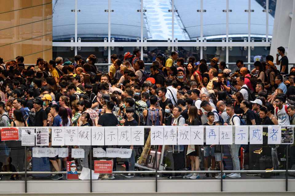  Protesters line up for a train at the airport station