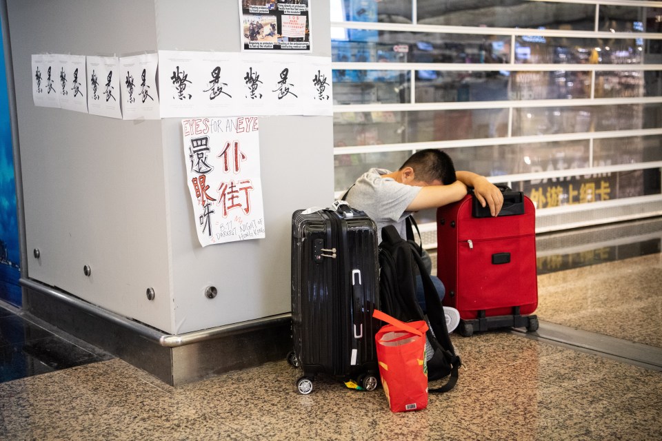  A passenger waits for updated information in the airport after flights were cancelled