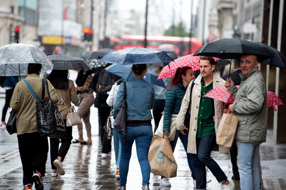  Shoppers had to use umbrellas as London's Oxford Street was hit by heavy rain today