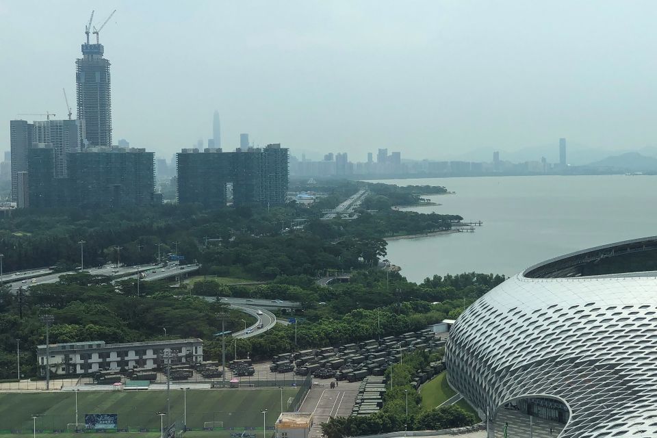  Trucks and armoured personnel carriers are seen outside the stadium, bordering Hong Kong in China's southern Guangdong province