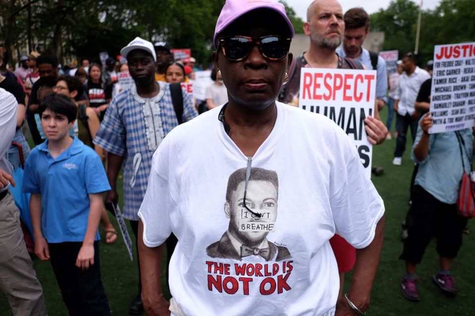  Demonstrators display placards during a rally to mark the one year anniversary of the death of Garner