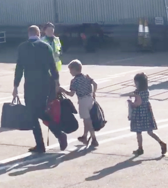  Kate and Wills walk across the runway with their own bags and children after flying on a FlyBe plane