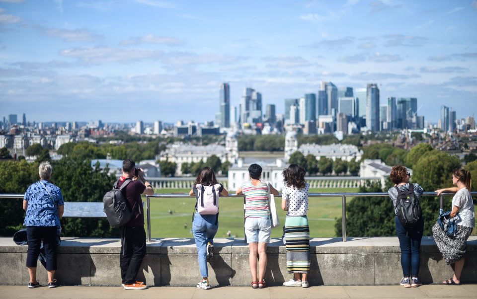  People look out at the London skyline from Greenwich Observatory as forecasters are predicting that the UK could have record setting temperatures this weekend