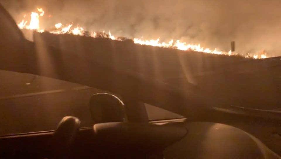  A photo taken from inside a passing car shows the fire ripping across the horizon 