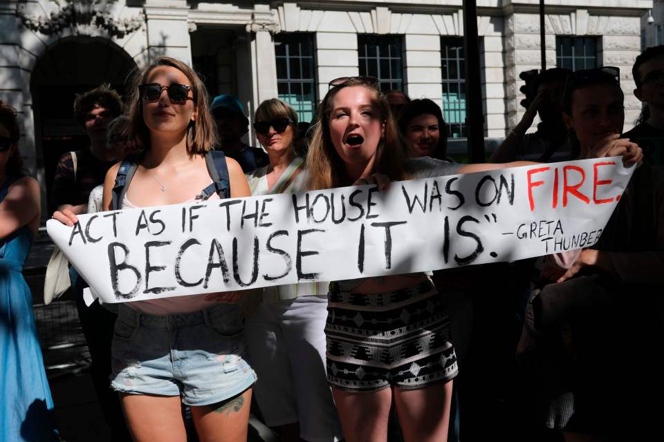  Protesters with a banner gather for a demonstration organised by climate change activists from Extinction Rebellion outside the Brazilian embassy in London