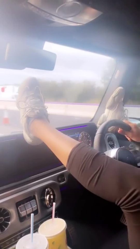  Rita Mahrez drives along a motorway with her feet up on the dashboard