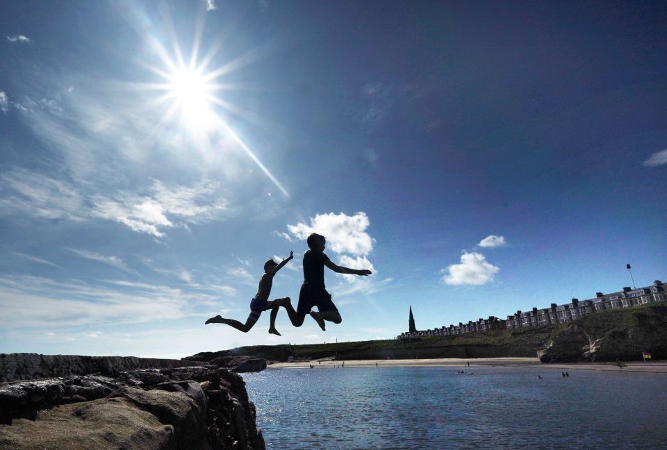  People jump in the sea at Cullercoats Bay in North Tyneside as temperatures reach the mid 20s ahead of a warm Bank Holiday forecast