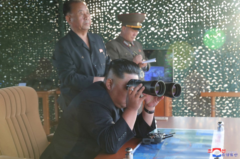  Close eye: Jong-un watches the launch while surrounded by military