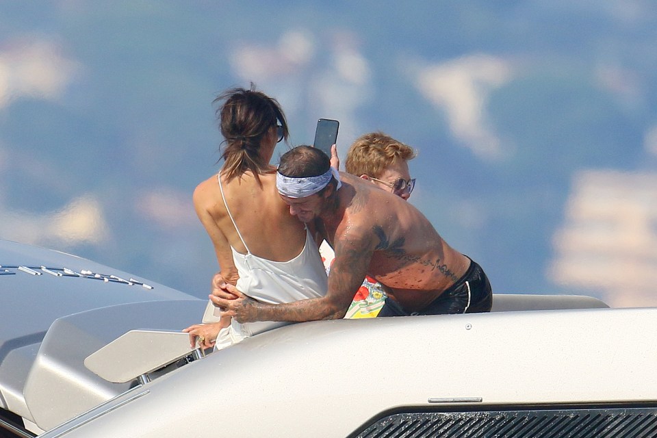  In a playful mood, smiling Becks wrapped his arms around Victoria