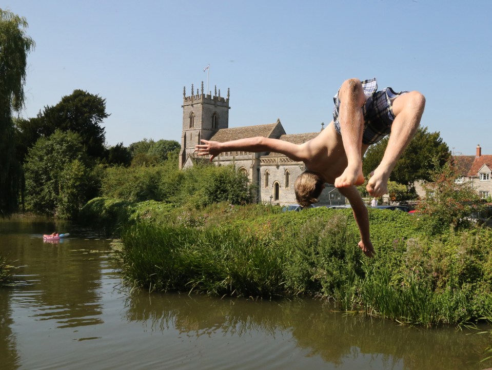  A youngster takes a flying leap into the River Brue at West Lydford, Somerset