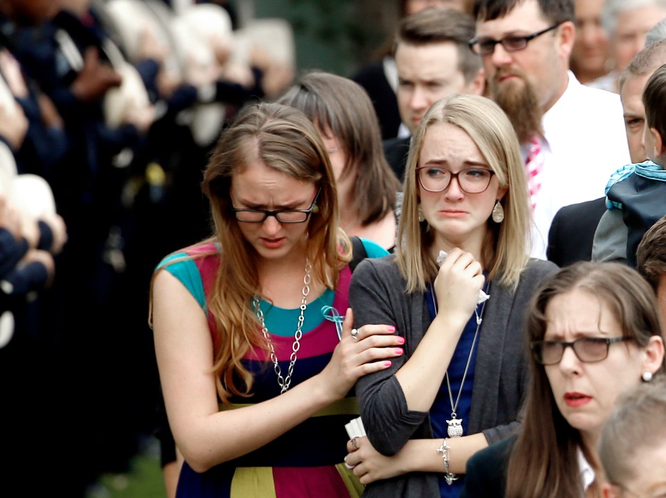  Cassidy Stay, center, is comforted as she watches her family's funeral