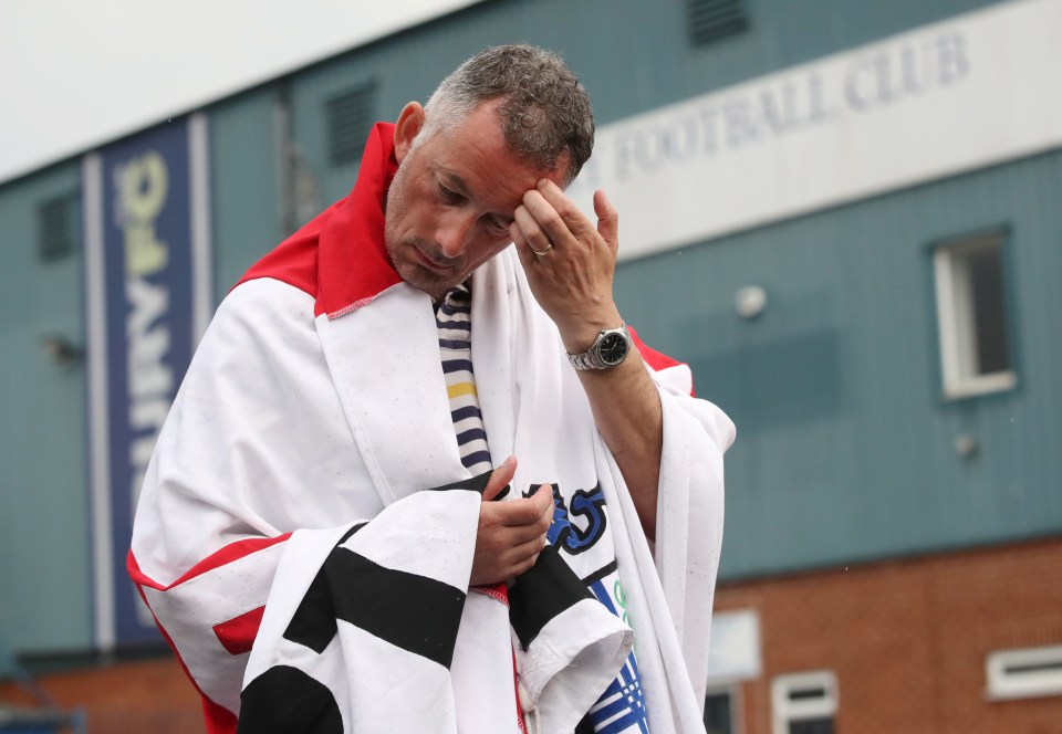  A heartbroken Bury fan stands outside Gigg Lane