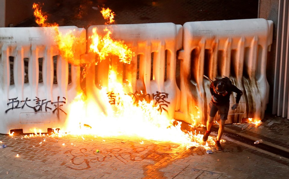  A demonstrator runs away from a burning barricade