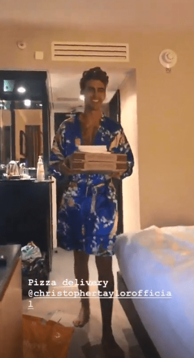  Chris Taylor, 29, collects a pizza delivery as Harley Brash, 19, films him in their hotel room