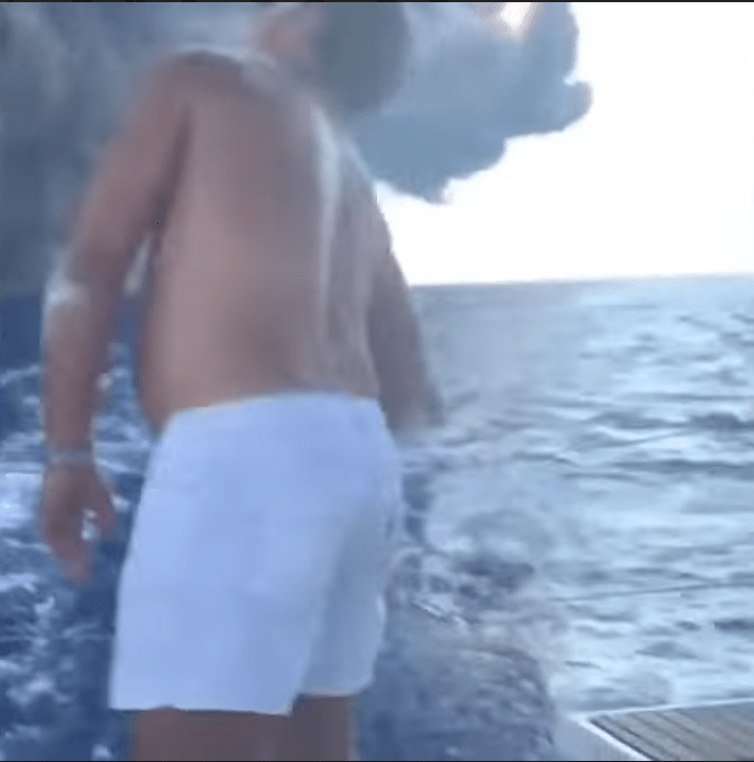  One man on board the boat looks up to see the cloud of billowing smoke