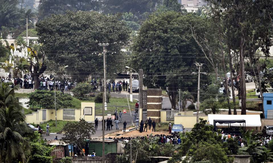  Policemen stand guard at the entrance of the cemetery during the funeral