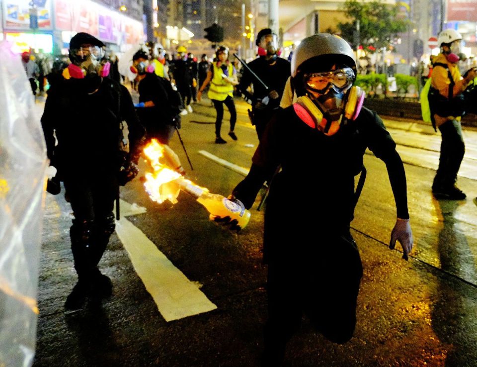  Demonstrators throw a Molotov cocktail at the police